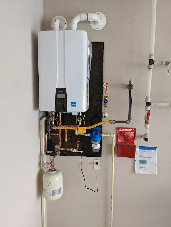 Professional plumber installing copper piping in a Jenner home